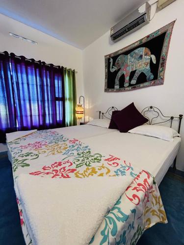 1 dormitorio con 2 camas y una foto de elefante en la pared en Chameleon Beach Resort, Cherai en Kochi
