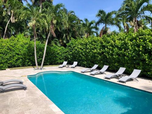 a swimming pool with lounge chairs next to a resort at Villa Palma-Hollywood Beach-Private Pool & Beachwalk! in Hollywood