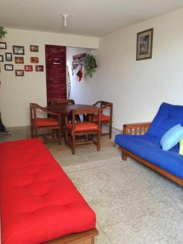 ein Wohnzimmer mit einem blauen Sofa und einem Tisch in der Unterkunft Visita lo mejor de Querétaro in Pedro Escobedo