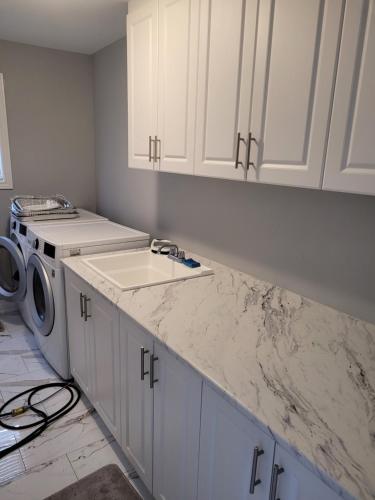 a kitchen with a sink and a washing machine at Individual home in Brampton