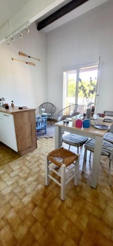 une pièce avec une table et des chaises et une cuisine dans l'établissement Duplex Camargue Village, au Grau-du-Roi