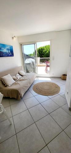 une chambre avec un lit et un sol carrelé dans l'établissement Terrasses 1 sur le Port de Plaisance, au Grau-du-Roi