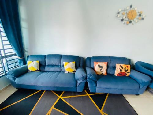 a blue couch in a living room with pillows on it at NS Vacation Home Muar with Kids Friendly Pool in Muar