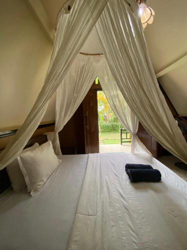 a bedroom with a bed with white mosquito netting at MATRAHAYA BUNGALOWS in Tetebatu