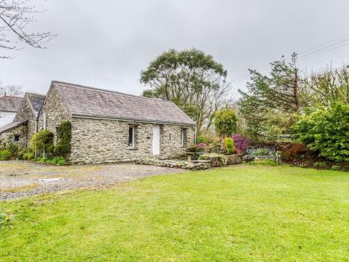 una antigua casa de piedra con un patio en Secluded Holiday Home in Ceredigion with Garden, en Pennant