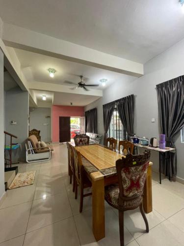 a dining room and living room with a table and chairs at Hidayah Homestay Tawau in Kampong Parit
