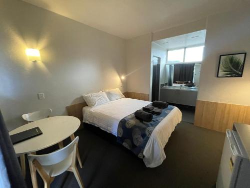 a small hotel room with a bed and a table at Northside Hotel Albury in Lavington