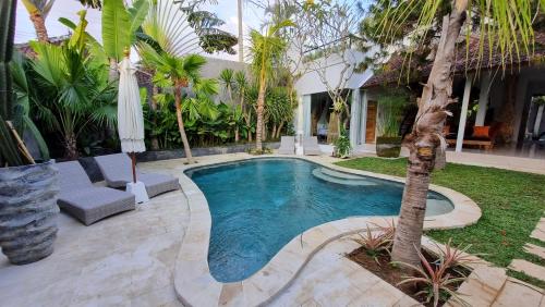 basen w ogrodzie z palmą w obiekcie Villa Loba w mieście Seminyak