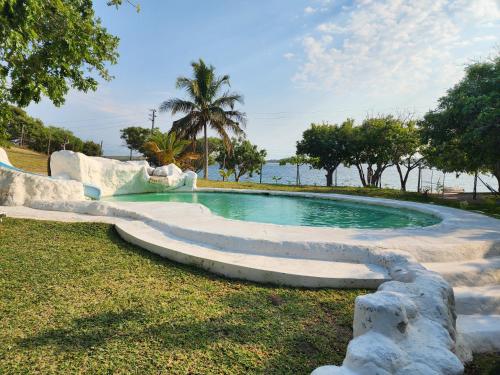 a swimming pool with a slide in the grass at Serenity Nhabanga, Bilene in Nhabanga