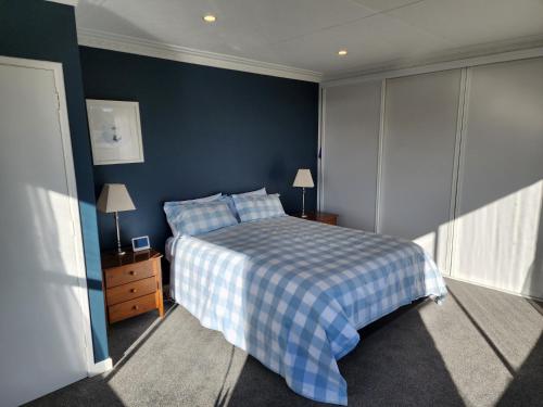 1 dormitorio con cama y pared azul en Roslyn Sanctuary Hereford St Dunedin, en Dunedin