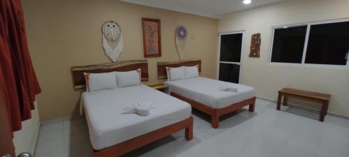 - une chambre avec 2 lits et une fenêtre dans l'établissement Casa Yaxkin, à Valladolid