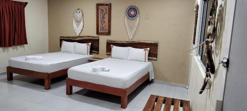 - une chambre avec 2 lits et des draps blancs dans l'établissement Casa Yaxkin, à Valladolid