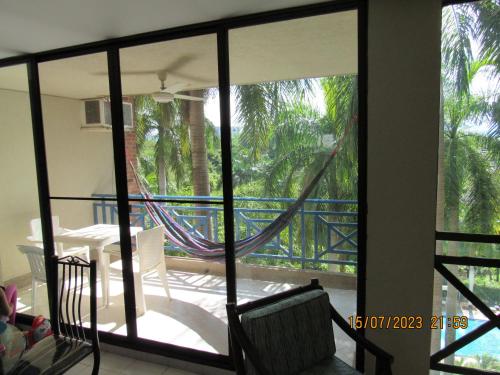 a balcony with a hammock and a table and chairs at Apartamento Girardot Resort in Girardot