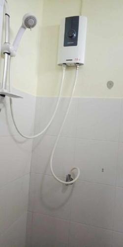 a shower with a hose attached to a wall at Najjamee Bungalows in Ko Yao Noi
