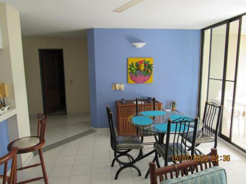 a dining room with a blue wall and a table and chairs at Condominio Girardot Resort INT 4 APTO 302 in Girardot