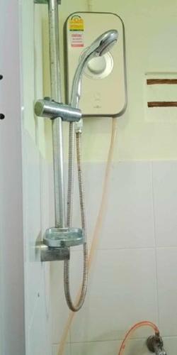 a shower head and a hose hanging on a wall at Najjamee Bungalows in Ko Yao Noi