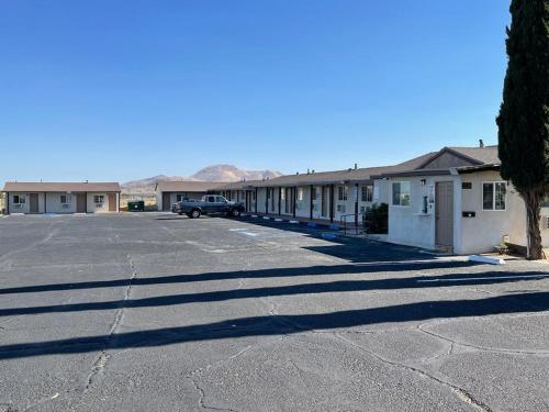 a parking lot with a car parked in front of buildings at Palm Inn in Mojave