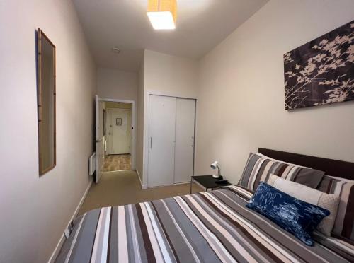 a bedroom with a large bed and a hallway at Aberdeen stay central 2-bedrooms Apt-No Party in Aberdeen