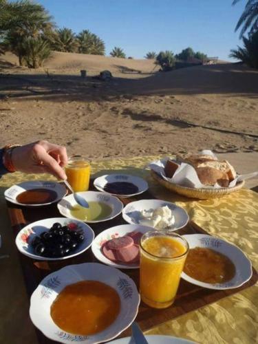 una mesa con comida y bebida en la playa en Hotel Janat Heritage, en Jaisalmer