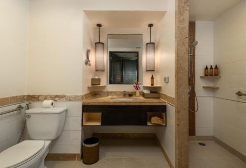 a bathroom with a toilet and a sink and a mirror at Centara Kata Resort Phuket - SHA Plus in Kata Beach