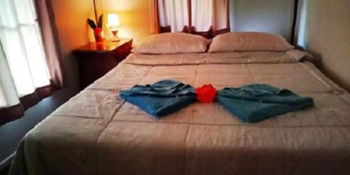 a bed with two towels on top of it at Najjamee Bungalows in Ko Yao Noi