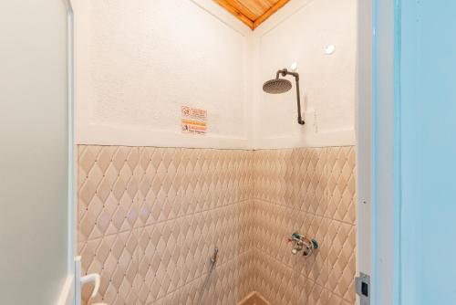 La salle de bains est pourvue d'une douche et de murs carrelés. dans l'établissement RedDoorz @ Niagara Waterpark, à Maracang-tua