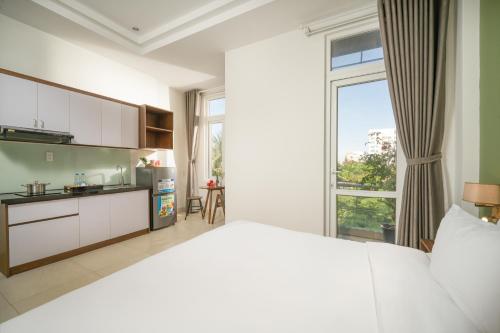 a bedroom with a large bed and a large window at Tashi Home in Da Nang
