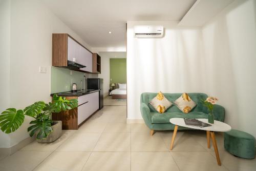 een woonkamer met een groene bank en een tafel bij Tashi Home in Da Nang