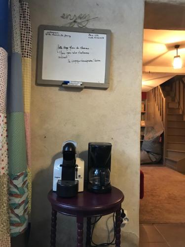 a table with two coffee makers on a wall at La maison de Fanny in Jarnioux