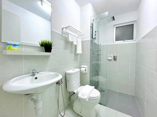 een witte badkamer met een toilet en een wastafel bij 2BR Alanis Suite With Balcony in Sepang