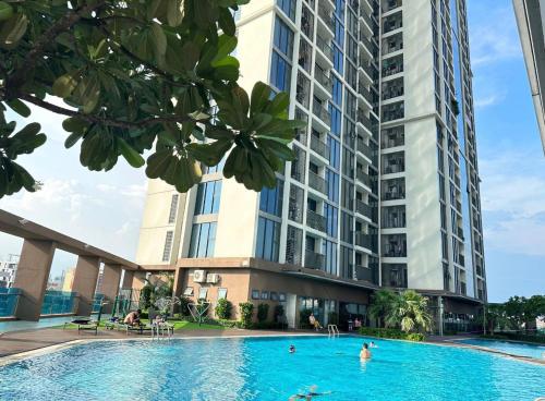a swimming pool in front of a tall building at Ecogreen HCM - DPL Homestay SG in Ho Chi Minh City