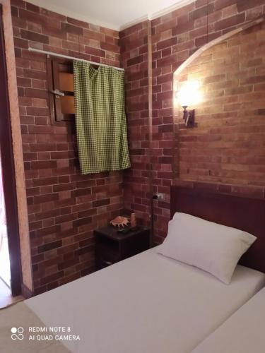 a bedroom with a bed and a brick wall at Studio in Sharm El Sheikh