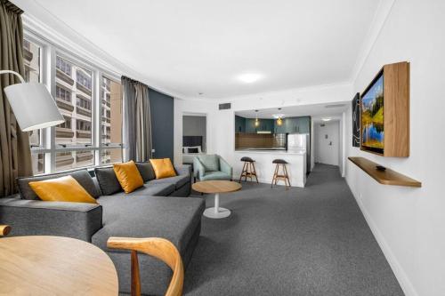 a living room with a couch and a kitchen at Chatswood Hub Self- Catering 815 in Sydney