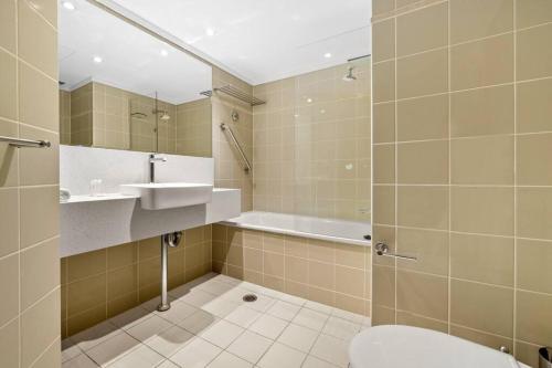 a bathroom with a toilet and a sink and a tub at Chatswood Hub Self- Catering 815 in Sydney