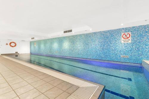 einen Pool in einem Fitnessraum mit blauen Fliesen in der Unterkunft Chatswood Hub Self- Catering 815 in Sydney