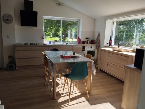une cuisine avec une table et des chaises dans une pièce dans l'établissement Gîte de Peyrinet, à Notre-Dame-de-Sanilhac