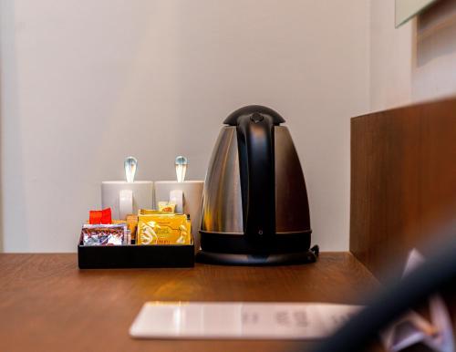 a coffee maker sitting on a table next to two candles at Crowne Plaza - Dar Es Salaam by IHG in Dar es Salaam