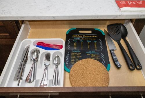 a drawer filled with utensils and a box with spoons at The Jade Place in Airdrie