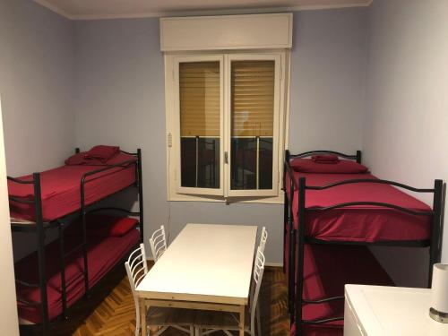 een kamer met 2 stapelbedden, een tafel en een raam bij Euro House in Modena