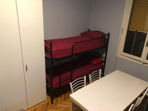 Zimmer mit 2 Etagenbetten und einem Tisch in der Unterkunft Euro House in Modena