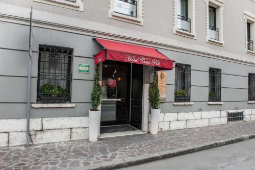 ein Restaurant mit einer roten Markise auf einem Gebäude in der Unterkunft Hotel Casa Poli in Mantua