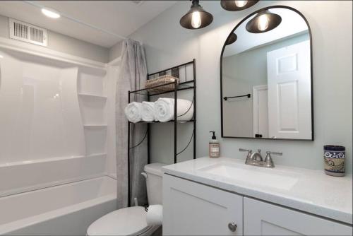 uma casa de banho com um lavatório, um WC e um espelho. em Dual-Family Retreat Sunlit Haven em Columbus