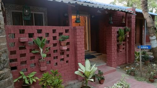 a brick wall in front of a house with plants at Wild Dunes Konark in Bālighāi