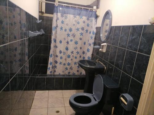 a bathroom with a black toilet and a shower at EL SEÑORIAL in Lima