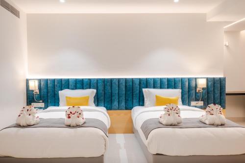 a bedroom with two beds with white rabbits on them at Clubway Grand A Boutique Hotel in Jorhāt