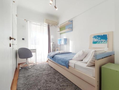 Schlafzimmer mit einem Bett, einem Schreibtisch und einem Stuhl in der Unterkunft Varkiza Sea View Apartment - Free Parking in Vari