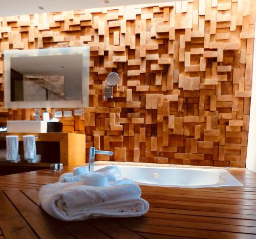 baño con bañera y pared de madera en Hotel Boutique MO17, en Querétaro