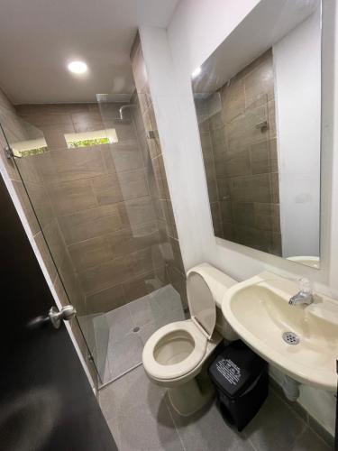 a bathroom with a shower and a toilet and a sink at Hotel De León Estadio in Medellín