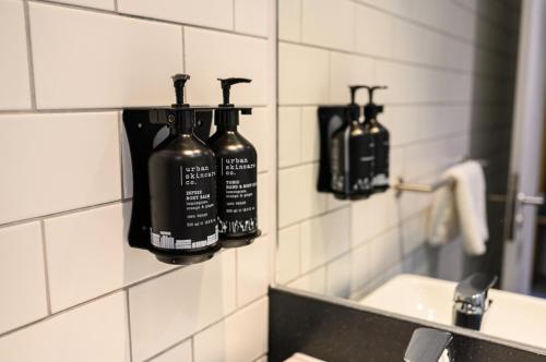 a bathroom with two bottles on the wall next to a sink at Holiday Inn South Normanton M1, Jct.28 by IHG in South Normanton