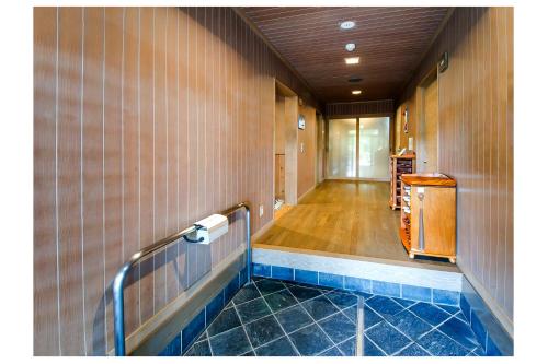 a bathroom with a tile wall and ailed hallway at 但馬長寿の郷　宿泊棟「夢」ロッジ in Yabu